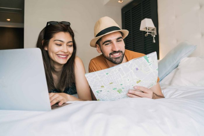 Couple organizing their trip at hotel room.