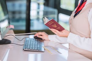 hôtesse de l'air vérifiant passeport sur un ordinateur