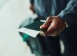 Main d'un homme avec un passeport et un billet d'avion