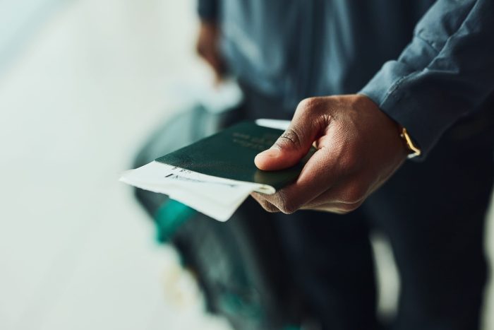 passeport en main Main d'un homme avec un passeport et un billet d'avion